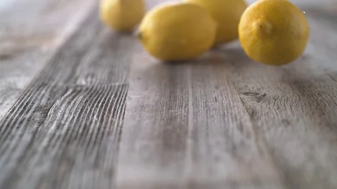 Lemons falling and rolling on a table. Slow Motion. Stock Footage 84927896
