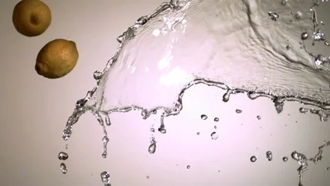 Lemons falling into splashing clear fresh water Stock Footage 327179784