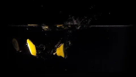 Lemons falling in the water on black background. Slow motion 1080p clip. Stock Footage 80759727