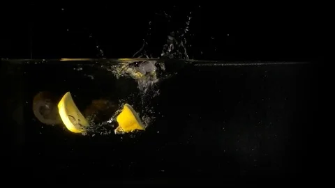Lemons falling in the water on black background. Slow motion 1080p clip. Stock Footage 80759741