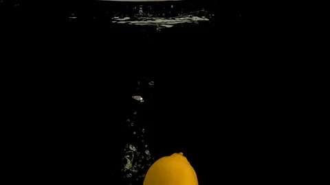 Lemons falling into water on black background. Bright high quality video Stock Footage 117277336