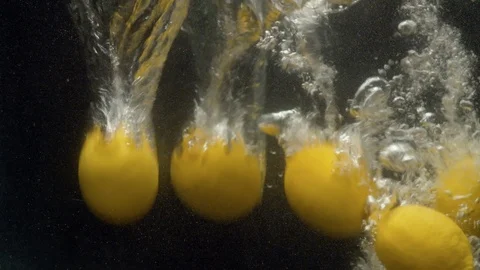 Lemons falling into the water with a splash Stock Footage 123704661