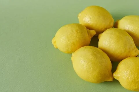 Lemons on a green background, selective focus. Stock Photos
