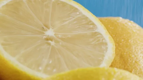 Lemons isolated on blue background, pouring water on fresh and ripe citrus Stock Footage 170725416