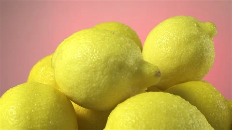 Lemons isolated rotating on pink/salmon background Stock Footage 62394707