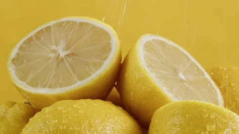 Lemons isolated on yellow background, pouring water on fresh and ripe citrus Stock Footage 170142299
