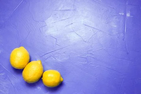 Lemons on a lilac background with space for text. Top view Stock Photos