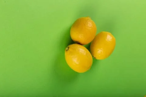 Lemons in the middle on a green backdrop Stock Photos