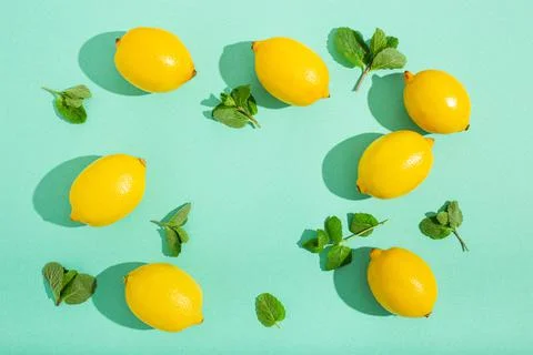 Lemons with mint on minimal blue background sun light hard shadows pattern 스톡 사진