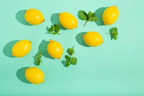 Lemons with mint on minimal blue background sun light hard shadows pattern Foto stock