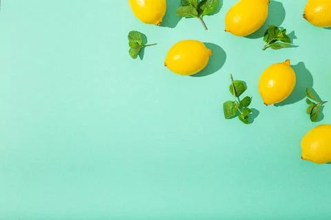 Lemons with mint on minimal blue background sun light hard shadows pattern Stock Photos
