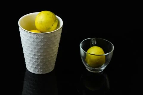 Lemons in white tea glasses closeup on isolated black background Stock Photos