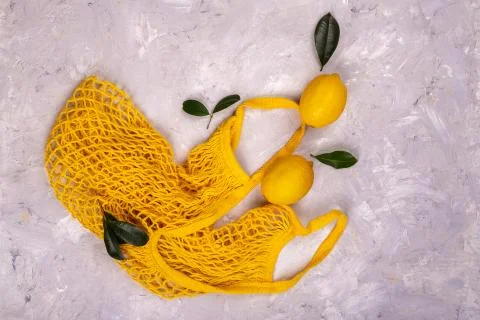Lemons in yellow string bag Stock Photos
