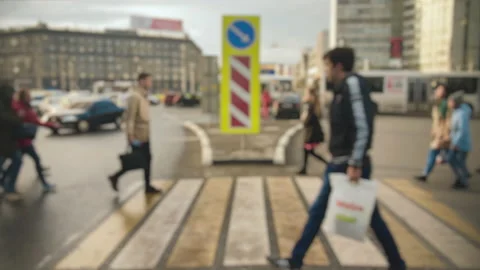 Lens blur, out of focus. A crowd of pedestrians cross the road against the Stock Footage 141992072