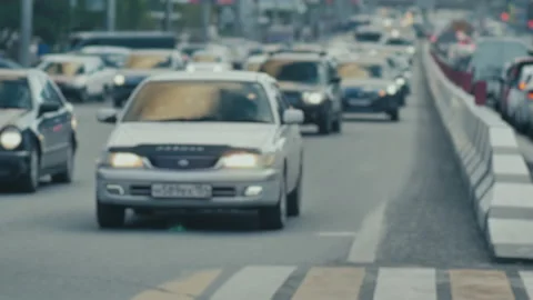 Lens blur, out of focus. A stream of cars, a busy street. A crowd of pedestrians Stock-Footage 142048524