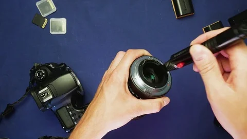 Lens cleaning with hands using a lenspen on a blue background, top view, 4K 動画素材 78603534