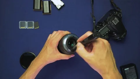 Lens cleaning with hands using a lenspen on a blue background, top view, 4K 動画素材 78603541