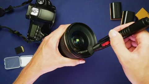 Lens cleaning with hands using a lenspen on a blue background, top view, 4K 動画素材 78603555
