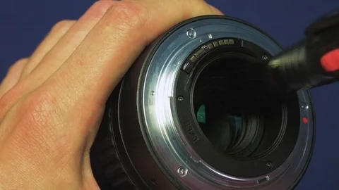 Lens cleaning with hands using a lenspen on a blue background, top view, closeup 動画素材 78603565