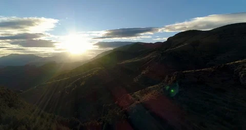 Lens flare looking into sunset over Pyrenees mountains drone aerial 4k Stock Footage 125756582