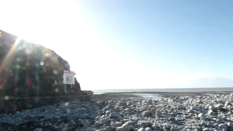 Lens Flared Panning Shot of a Beach and a Hillside Video stock 85394670