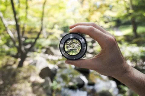 Lens focus on forest stream through camera lens Stock Photos