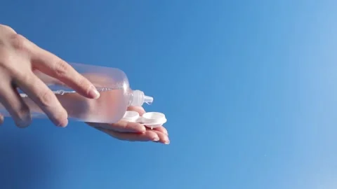 Lens solution, female hands pouring cleaning liquid from a bottle into a co.. Stock Footage 255441198