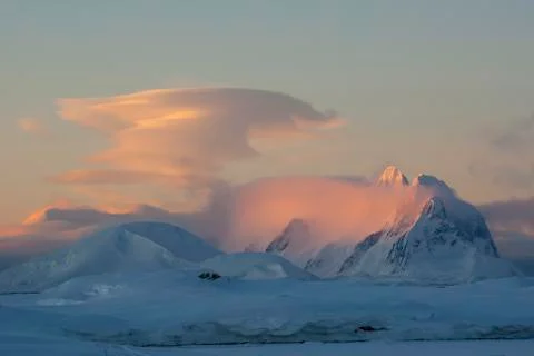 Lenticular cloud at sunset over the mountains of the Antarctic Peninsula Stock Photos