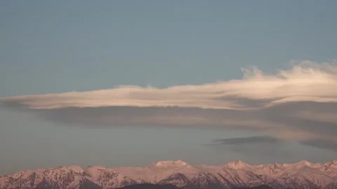 Lenticular clouds hovering above snowy mountain - Cloud Shapes and Snow Covered Stock Footage 339367936
