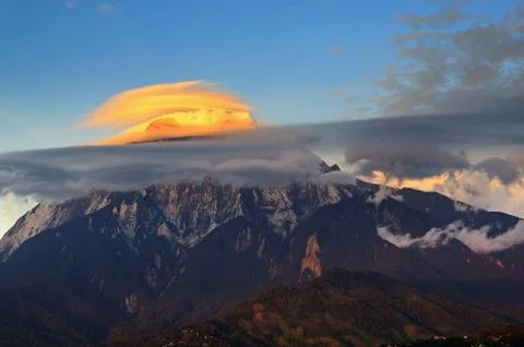 Lenticular clouds illuminated by sunset light over Mount Kinabalu in Sabah Bo Stock Photos