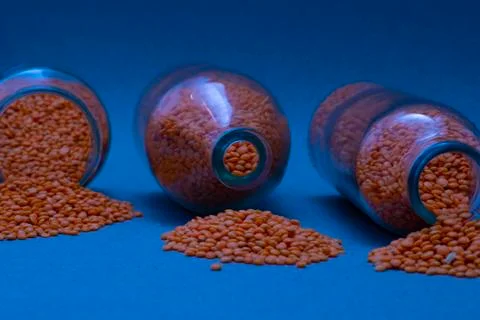 Lentils in a jars on a blue background, close up Stock Photos