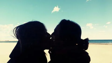 Lesbian couple kissing on the beach Stock Photos