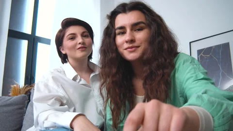 Lesbian couple making a selfie or video call using smart phone or laptotp. Laugh Stock Footage 166688229