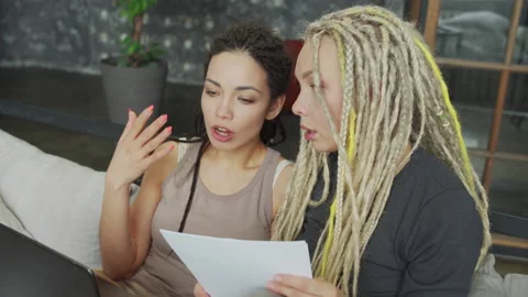 Lesbian couple sitting on the sofa using laptop and learning Stock Footage 156210551