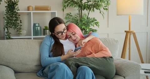 Lesbian couple using mobile phone at home Stock Footage 147184888