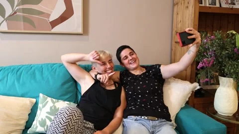 Lesbian Millennials Enjoying Sofa Selfie with smartphone Stock Footage 274674831