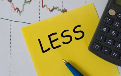LESS word on yellow sheet on table with pen, calculator and graph Stock Photos