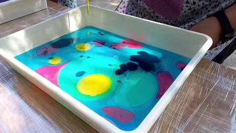 Lesson on drawing technique Ebru. child drawing, creating pattern on water. Video stock 256146541