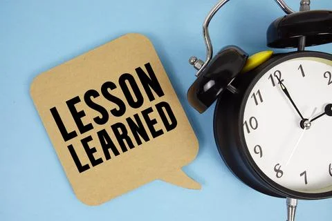 Lesson Learned text with alarm clock on blue background Stock Photos