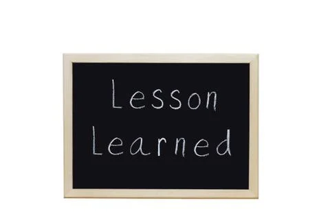 Lesson Learned written with white chalk on blackboard. Stock Photos
