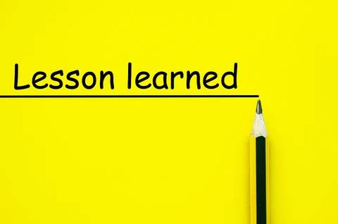 Lesson learned written on yellow paper background. Lesson concept. Stock Photos