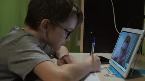 Lesson online. a boy with glasses listens to a lesson. a young teacher explains Stock Footage 147447366
