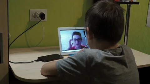 Lesson online. the boy writes down a task in a notebook. a young teacher Stock Footage 147882498