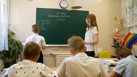 Lesson at primary school. Mathematical example on the blackboard Stock Footage 93889702