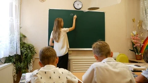 Lesson at primary school. Teacher Writes on the Blackboard Stock Footage 93889849