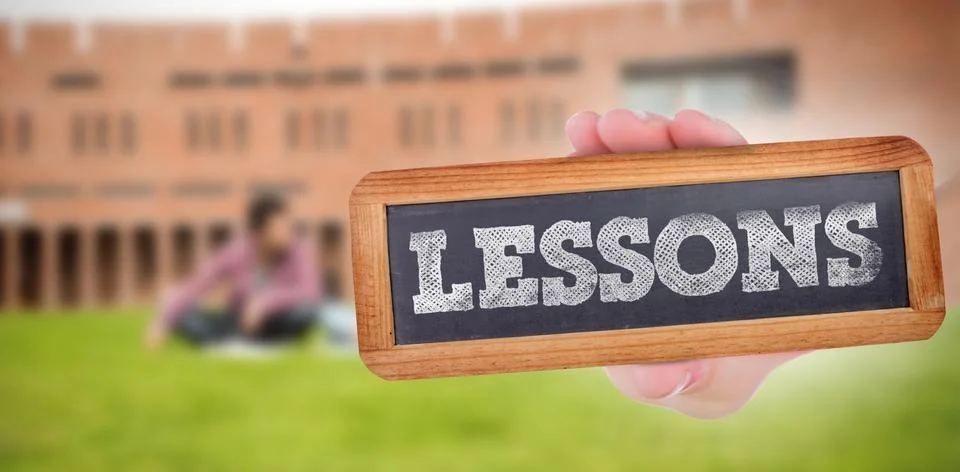 Lessons against students using laptop in lawn against college building Fotos de archivo