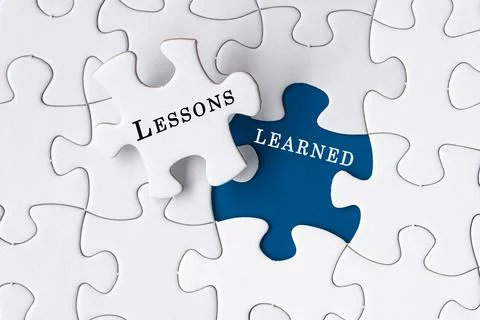 Lessons learned text on Jigsaw Puzzle over blue background. Stock Photos