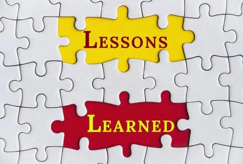 Lessons learned text on Jigsaw Puzzle with yellow and red background. Foto stock