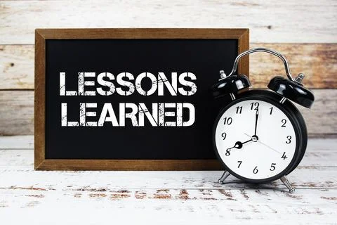 Lessons Learned text message and alarm clock on wooden background Stock Photos