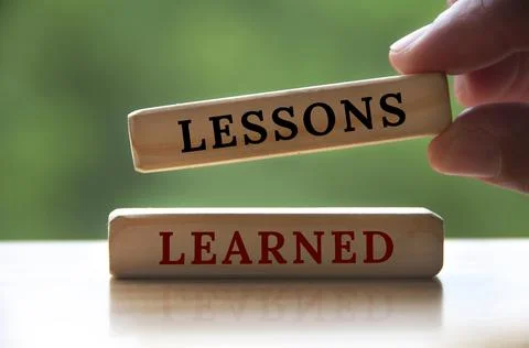 Lessons learned text on wooden blocks with hand holding Foto stock